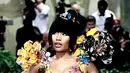 Nicki Minaj berjalan di karpet Met Gala mengenakan gaun kuning dari Marni. Ia mengenakan gaun jam pasir pahatan, yang dilukis dengan tangan, dan dihiasi dengan bunga tiga dimensi. [@marni]
