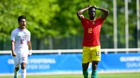 Ekspresi kekecewaan striker Guinea, Algassime Bah usai sepakan penaltinya ditahan Ernando Ari Sutaryadi dalam laga play-off Olimpiade 2024 Paris, Kamis (9/5/2024) malam WIB. (AFP/Miguel Medina)