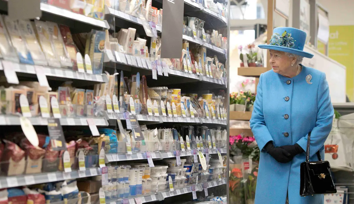 Ratu Inggris Elizabeth II melihat makanan di rak-rak pasar swalayan Waitrose selama kunjungannya ke Kota Poundbury, Inggris (27/10). Ratu Inggris yang berumur 90 tahun ini datang ke Poundbury juga untuk meresmikan patung ibundanya. (Reuters/Justin Tallis)