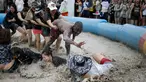 Sejumlah turis mengikuti sebuah permainan dalam Festival lumpur Boryeong di pantai Daecheon, Boryeong, Korea Selatan, (15/7). Festival lumpur Boryeong selalu mengadakan berbagai perlombaan yang menggunakan arena berlumpur. ( REUTERS/Kim Hong-Ji)