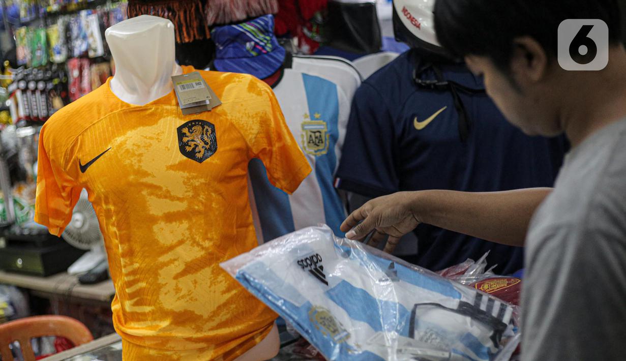 Pembeli melihat jersey Argentina tim peserta Piala Dunia 2022 Qatar di salah satu kios di Blok B Pasar Tanah Abang, Jakarta, Jumat (18/11/2022). Turnamen sepak bola Piala Dunia 2022 Qatar yang akan berlangsung selama sebulan dan dimulai pada Minggu (20/11/2022) turut mendongkrak penjualan jersey. (Liputan6.com/Faizal Fanani)