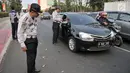 Petugas Dinas Perhubungan DKI Jakarta melakukan sosialisasi uji coba perluasan sistem ganjil genap kepada pengendara di kawasan Pramuka, Jakarta, Senin (12/8/2019). Dinas Perhubungan DKI Jakarta melakukan uji coba perluasan sistem ganjil genap hingga 6 September 2019. (merdeka.com/Iqbal Nugroho)