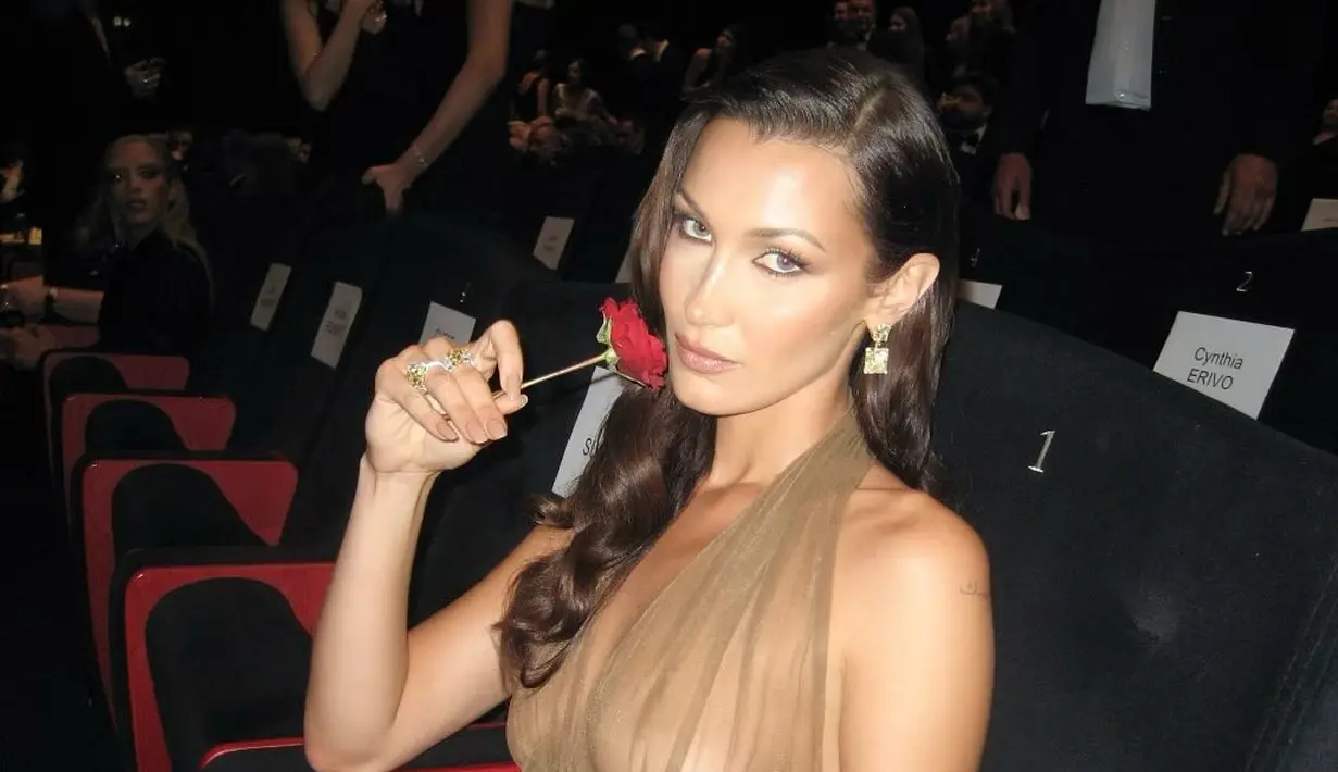 Bella Hadid tampil slay mengenakan sebuah dress berani yang transparan dengan detail halter-neck. [Foto: Instagram/bellahadid]