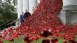 Pajangan karya seni bunga poppy bertajuk 'Weeping Window' dipasang di The Imperial War Museum, London, Kamis (4/10). Karya seni tersebut terdiri dari ratusan ribu patung bunga poppy berwarna merah. (AP Photo/Kirsty Wigglesworth)