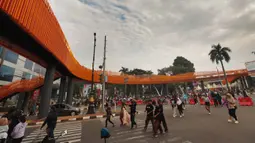 Warga beraktivitas di sekitar Jembatan Penyeberangan Orang (JPO) di Jalan Tegar Beriman, Cibinong, Kabupaten Bogor, Jawa Barat, Minggu (14/6/2026). (Kapanlagi.com/Budy Santoso)