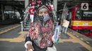 Perempuan pengguna KRL membawa bunga dan healthy kit yang diberi petugas KAI Commuter di Stasiun Jatinegara, Jakarta, Selasa (22/12/2020). Kegiatan tersebut dalam rangka memperingati Hari Ibu yang jatuh setiap tanggal 22 Desember. (Liputan6.com/Faizal Fanani)