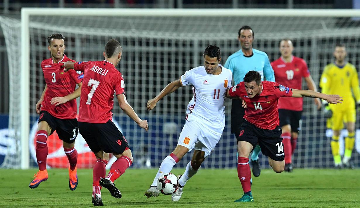 Gelandang Spanyol, Vitola, berusaha melewati gelandang Albania, Taulant Xhaka. Pada laga ini Spanyol menggunakan formasi 3-4-3, sementara Albania mengunakan skema 4-5-1. (AFP/Andrej Isakovic) 
