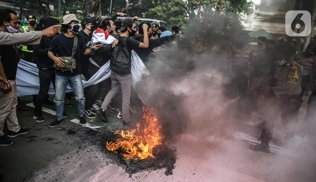 Massa yang tergabung dalam gerakan nasional tolak reklamasi (Gentar) membakar ban saat aksi didepan Gedung Balaikota, Jakarta, Rabu (8/7/2020). Reklamasi Pantai Ancol dianggap sebagai bentuk perampasan pantai publik atas akses masyarakat nelayan pesisir Jakarta.  (Liputan6.com/Faizal Fanani)