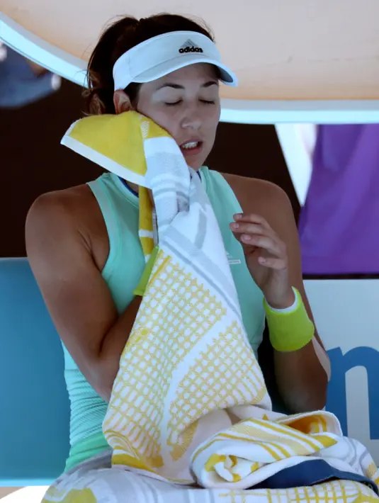 Petenis wanita asal Spanyol, Garbine Muguruza mengelap keringat saat istirahat dalam pertandingan Australia Terbuka di Melbourne, Australia, (22/1). Teriknya cuaca di Australia Terbuka, membuat para pemain kepanasan. (AP Photo/Aaron Favila)