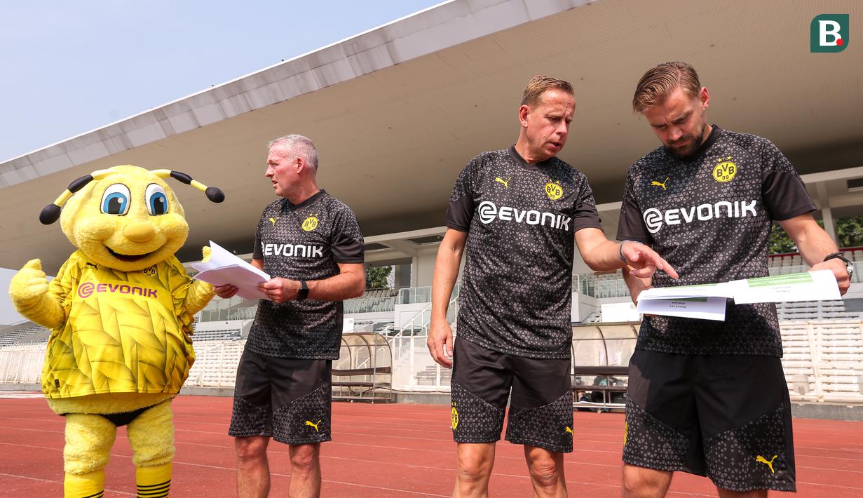 Tiga legenda Borussia Dortmund, Paul Lambert (kedua kiri), Joerg Heinrich (kedua kanan), dan Marcel Schmelzer (kanan) berdiskusi sebelum memberikan coaching clinic kepada siswa Papua Football Academy di Stadion Madya, Senayan, Jakarta, Jumat (08/09/2023). (Bola.com/Bagaskara Lazuardi)