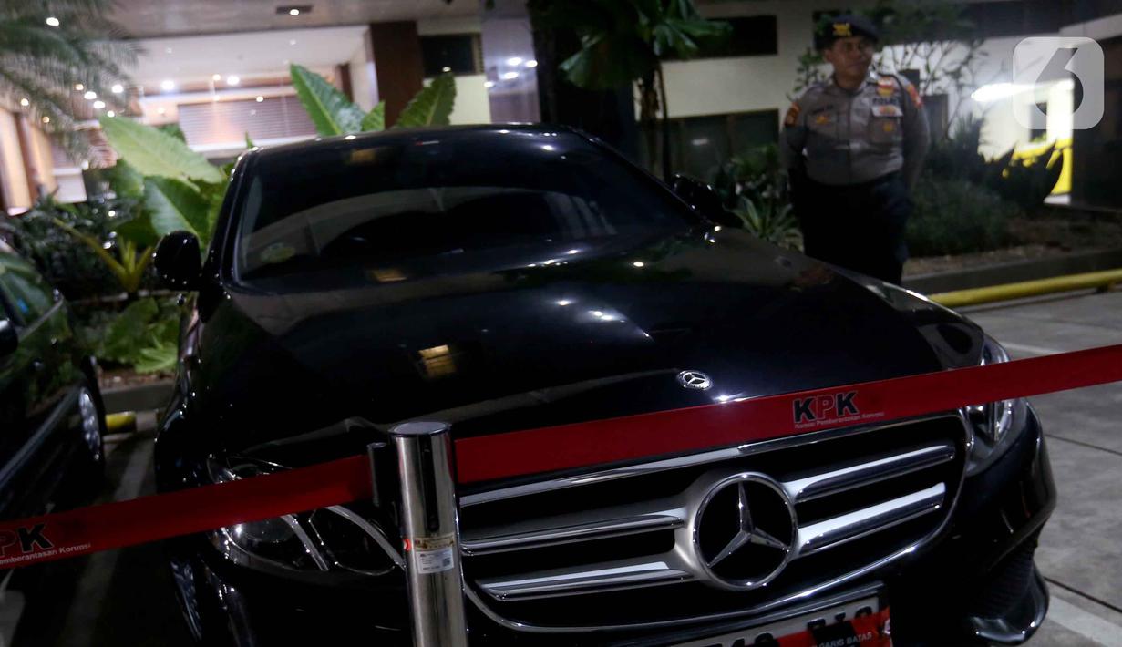 Petugas menjaga salah satu mobil yang disita dari hasil Operasi Tangkap Tangan (OTT) yang menjerat Kepala Kantor Imigrasi Jakarta Barat tiba di Gedung Merah Putih Komisi Pemberantasan Korupsi (KPK), Jakarta, Rabu (3/6/2026). (Liputan6.com/Helmi Fithriansyah)