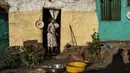 Seorang perempuan berdiri di depan pintu sebuah rumah di Kota Gondar, Ethiopia pada 09 November 2020. (Photo by EDUARDO SOTERAS / AFP)