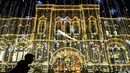 Pejalan kaki melewati toserba GUM dengan dekorasi lampu yang menghiasi sebuah jalan pusat kota Moskow, Senin (18/12). Salah satu sudut kota di Rusia itu didekorasi dengan lampu dan pernak-pernik perayaan Natal dan Tahun Baru. (AFP PHOTO / Yuri KADOBNOV)