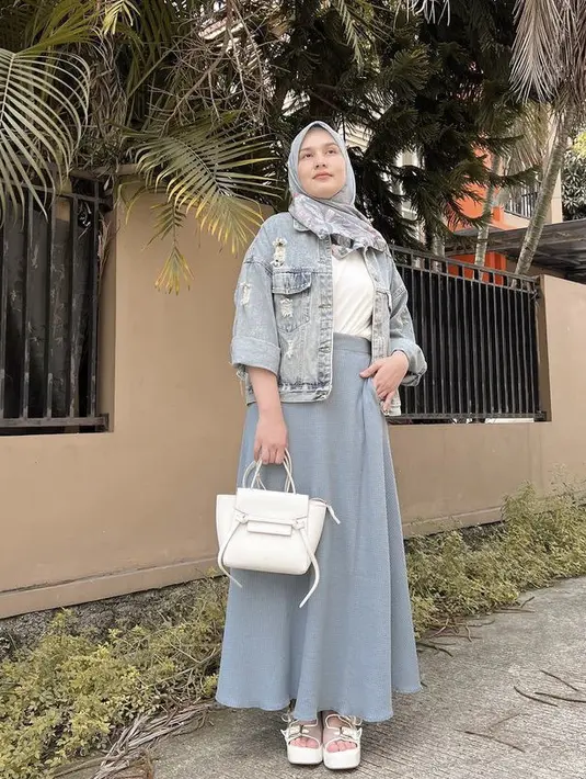 Sementar itu, influencer Dwi Handa mengenakan jaket jeans ripped yang dipadukan inner tshirt putih dan long skirt abu-abu yang serasi dengan kerudungnya. Ia pun mengenakan hand bag dan sandal warna putih. @dwihandaanda