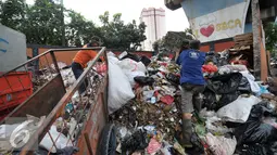 Petugas kebersihan mengumpulkan sampah di lokasi tempat pembuangan sampah sementara (TPSS), Pasar Baru, Jakarta, Jumat (25/11). Para cagub juga harus memiliki program untuk mengatasi permasalahan lingkungan di Jakarta. (Liputan6.com/Yoppy Renato)