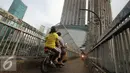 Pengendara sepeda motor melintas di atas Jembatan Penyeberangan Orang (JPO) di kawasan Grogol, Jakarta, Rabu (4/5). JPO yang seharusnya diperuntukkan bagi pejalan kaki itu kini sering dimanfaatkan pengendara motor. (Liputan6.com/Gempur M Surya)
