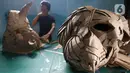 Perajin menyelesaikan pembuatan pajangan kepala badak dari kardus di Workshop Bumi Kardus, Depok, Jawa Barat, Jumat (15/7/2022). Kerajinan berbahan baku kardus tersebut dijual dengan harga Rp 400 ribu hingga Rp 60 juta tergantung tingkat kesulitan dan ukuran. (Liputan6.com/Herman Zakharia)