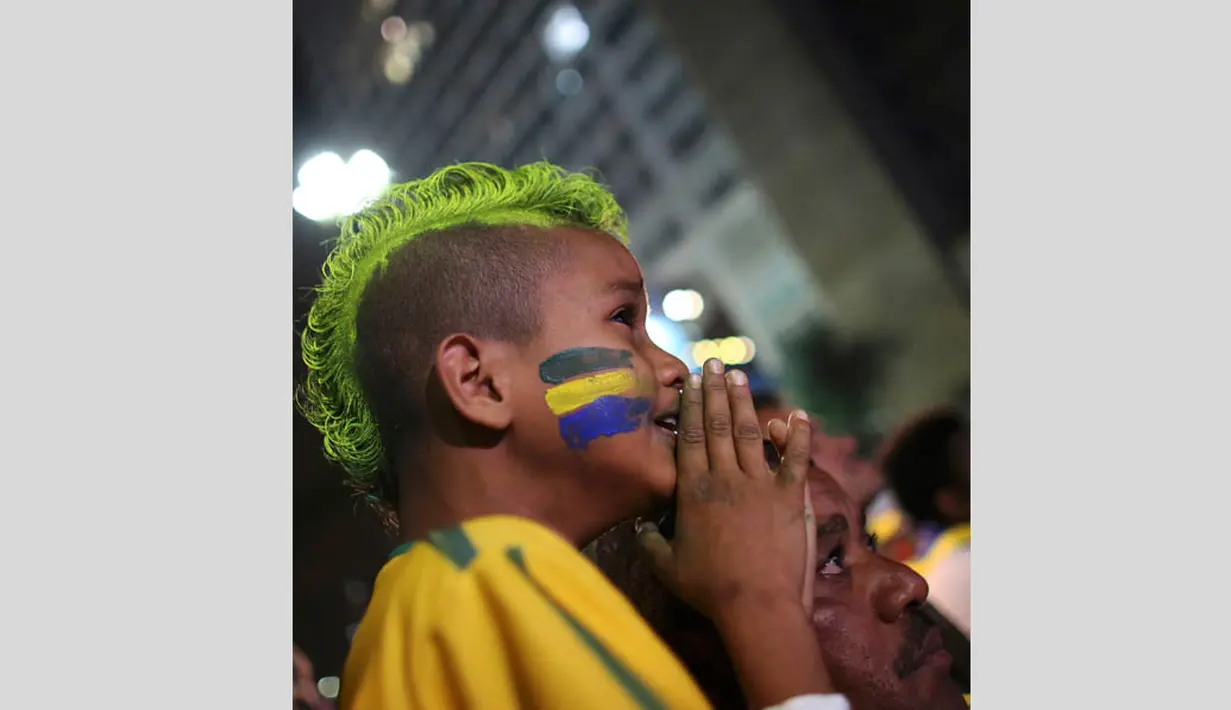 Seorang bocah tampak tidak tega melihat kekalahan David Luiz dkk setelah gawang Brasil kebobolan pada babak semifinal Piala Dunia 2014 melawan Jerman, Selasa (8/7/14). (REUTERS/Nacho Doce) 