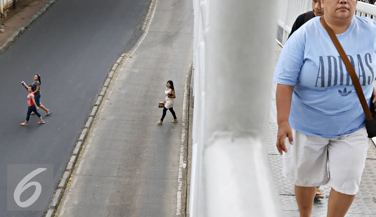 Pejalan kaki menyeberang di bawah Jembatan Penyeberangan Orang (JPO) di Jakarta, Kamis (19/11). Selain membahayakan keselamatan, perilaku buruk pejalan kaki tersebut juga menjadi salah satu penyebab kemacetan di Ibu Kota. (Liputan6.com/Immanuel Antonius)