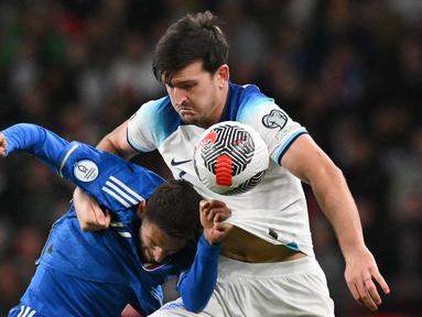 Pemain Timnas Inggris, Harry Maguire (kanan), berebut bola dengan pemain Timnas Italia, Domenico Berardi dalam laga lanjutan Kualifikasi Euro 2024 yang digelar di Wembley, London pada Rabu (18/10/2023) dini hari WIB. (AFP/Glyn Kirk)