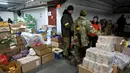 Prajurit Pasukan Pertahanan Teritorial Ukraina, cadangan militer Angkatan Bersenjata Ukraina, menerima makanan di gudang di garasi bawah tanah yang telah diubah menjadi pangkalan pelatihan dan logistik di Kiev, pada Jumat (11/3/2022). (Sergei SUPINSKY / AFP)