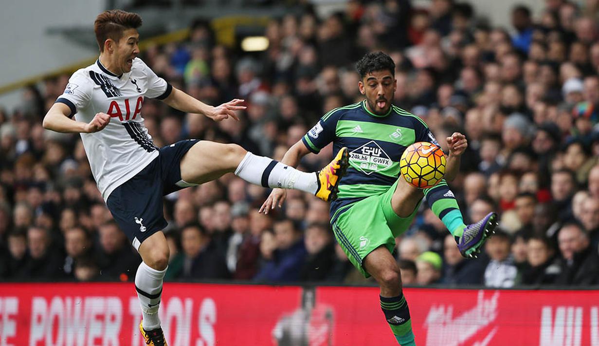 Gelandang Tottenham, Son Heung-Min, berebut bola dengan pemain Swansea, Neil Taylor. Sementara bagi Tottenham, hasil ini membuat mereka semakin memepet pimpinan klasemen dengan jarak dua poin. (Reuters/Russell Cheyne)