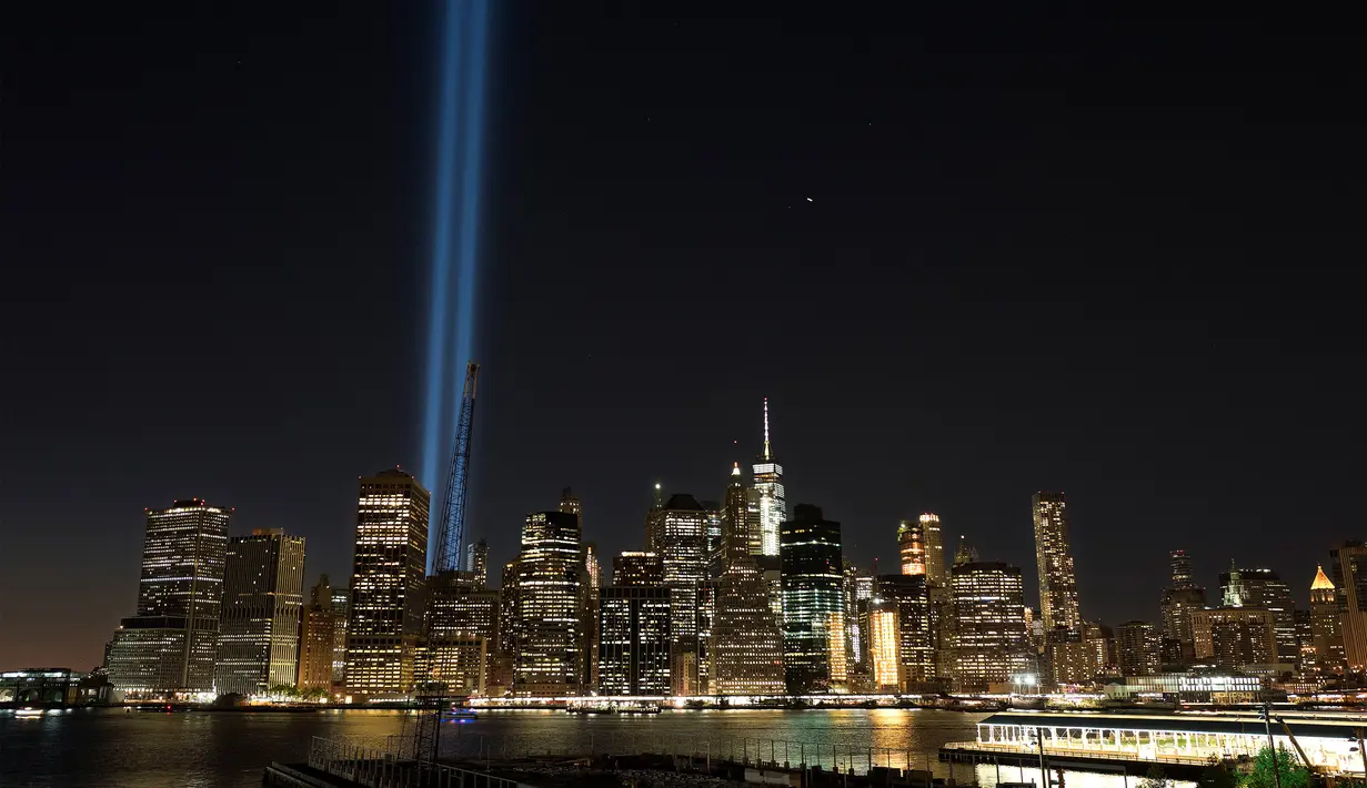 Instalasi seni ‘Tribute in Light’ hiasi langit Manhattan di lokasi kejadian 9/11 Kota New York, Minggu (10/9). Pembajak menabrakan dua pesawat jet penumpang ke menara World Trade Center pada jam sibuk Kota New York. (AP Photo/Mark Lennihan)