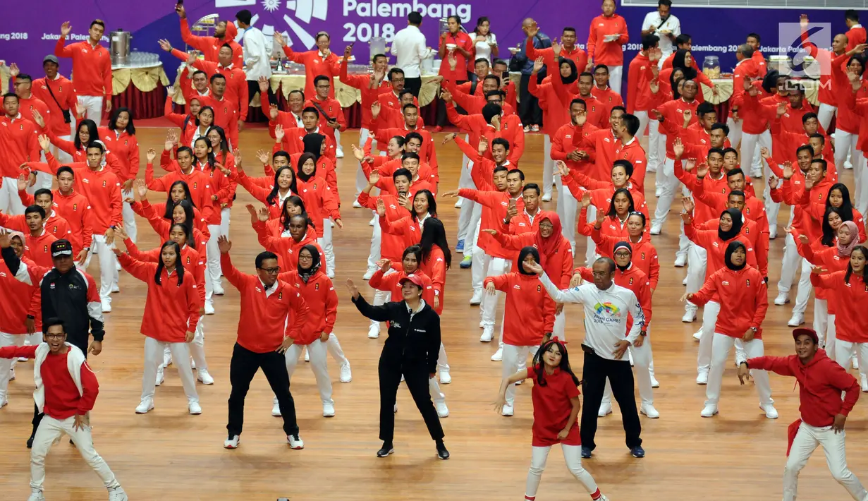 Menko PMK, Puan Maharani (tengah jaket hitam) bersama sejumlah atlet, pelatih dan official menari lagu tema Asian Games 2018 usai upacara pengukuhan di Istora Senayan, Jakarta, Minggu (5/8). (Liputan6.com/Helmi Fithriansyah)