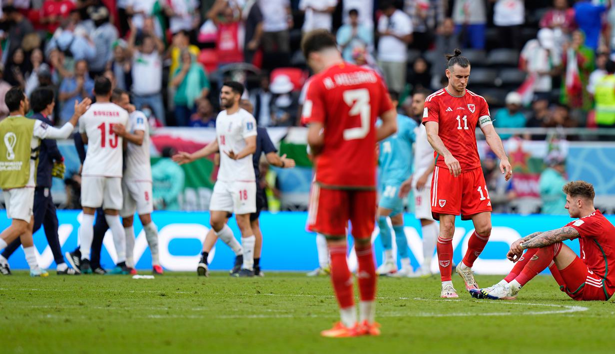 Pemain Wales Gareth Bale (kedua kanan) bersama rekan setimnya pada akhir pertandingan sepak bola Grup B Piala Dunia 2022 antara Wales dan Iran di Stadion Ahmad Bin Ali, Al Rayyan, Qatar, Jumat (25/11/2022). Iran mengalahkan Wales dengan skor 2-0. (AP Photo/Pavel Golovkin)