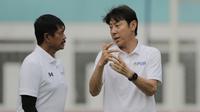Manajer pelatih Timnas Indonesia, Shin Tae-yong, berbincang dengan Indra Sjafri, saat sesi latihan di Stadion Wibawa Mukti, Cikarang, Senin (13/1/2020). Sebanyak 51 pemain mengikuti seleksi untuk memperkuat skuat utama Timnas Indonesia U-19. (Bola.com/M I