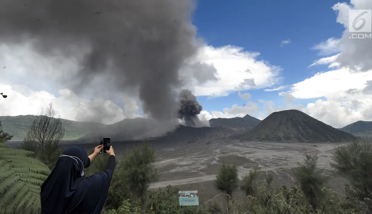 Wisatawan mengabadikan gambar erupsi Gunung Bromo di kawasan Ngadisari, Probolinggo, Jawa Timur, Senin (25/3). Erupsi Gunung Bromo dengan status level II (waspada) menjadi daya tarik bagi wisatawan untuk menikmati atraksi alam. (merdeka.com/Arie Basuki)