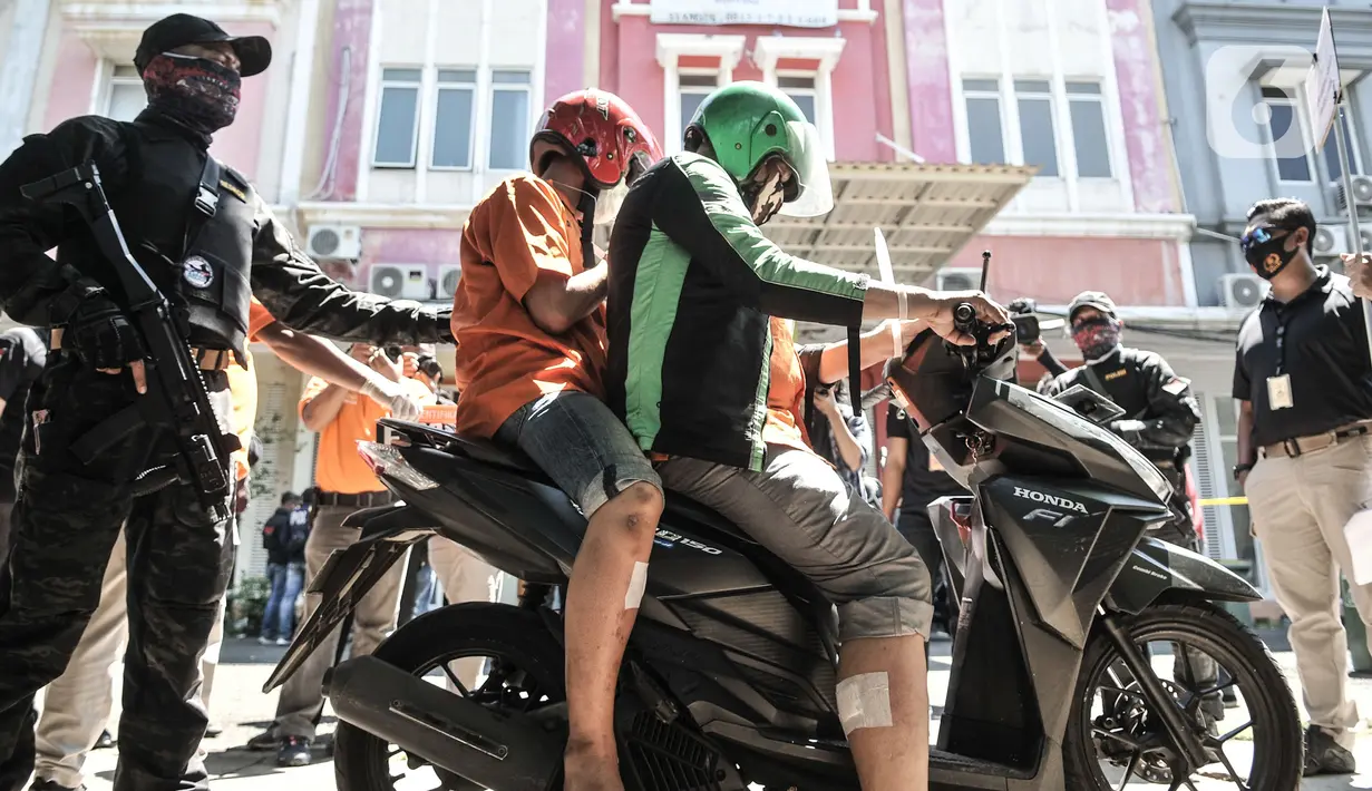 Tersangka melakukan salah satu adegan saat rekonstruksi kasus pembunuhan Sugianto (51) di ruko Royal Gading Square, Kelapa Gading, Jakarta, Selasa (25/8/2020). Rekonstruksi melibatkan 12 tersangka termasuk NL, karyawati korban yang berperan sebagai dalang pembunuhan. (merdeka.com/Iqbal S. Nugroho)