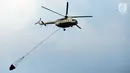 Helikopter water bombing membawa air untuk disiramkan ke arah ban yang dibakar massa di kawasan Slipi, Jakarta, Rabu (22/5/2019). Air dijatuhkan dari udara ke arah api yang berasal dari ban bekas. (merdeka.com/Imam Buhori)
