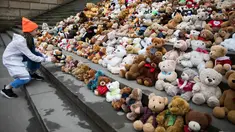 Seorang siswa meletakkan satu boneka beruang atau Teddy Bears di tangga Concert Hall, Berlin, Kamis (15/3). Kelompok bantuan kemanusiaan World Vision melakukan aksi pengumpulan 740 boneka beruang. (AFP PHOTO/Odd ANDERSEN)