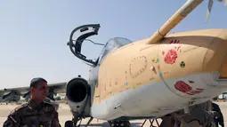 Salah satu anggota militer Irak terlihat mengamati pesawat jet jenis Sukhoi Su-25 yang baru tiba di Pangkalan Udara al-Muthanna, Baghdad, (1/7/2014). (REUTERS/ Stringer) 