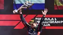 Pembalap Red Bull Racing, Max Verstappen merayakan kemenangan setelah finis tercepat di Formula 1 GP Italia 2023 yang berlangsung di Sirkuit Monza, Italia, Minggu (03/09/2023). Verstappen sukses mencatatkan 10 kemenangan secara beruntun di ajang F1 mengungguli rekor milik Sebastian Vettel (AFP/Marco Bertorello)
