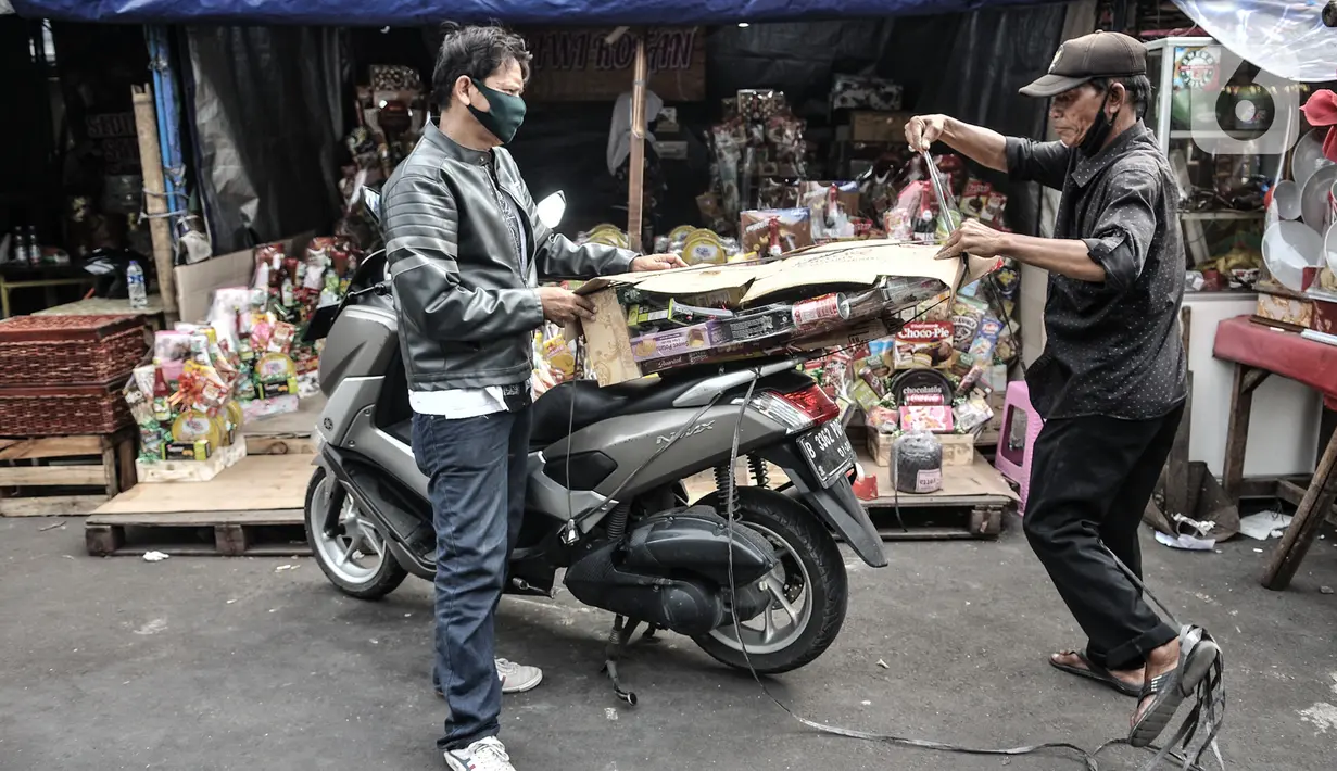 Pedagang membungkus parsel untuk dibawa pembeli di kawasan Cikini, Jakarta, Selasa (29/12/2020). Untuk saat ini, pedagang menjual parsel mulai dari Rp 150.000 hingga Rp 2 juta per buah, tergantung permintaan dan kerumitan pembuatan. (merdeka.com/Iqbal S. Nugroho)
