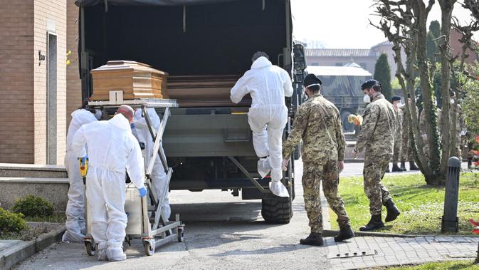 Petugas membawa peti mati berisi jasad korban virus corona COVID-19 yang diturunkan dari truk militer di pemakaman Ferrara, Italia, Sabtu (21/3/2020). Dari mereka yang awalnya terinfeksi COVID-19 secara nasional, 6.072 orang telah dinyatakan pulih sepenuhnya. (Massimo Paolone/LaPresse via AP)