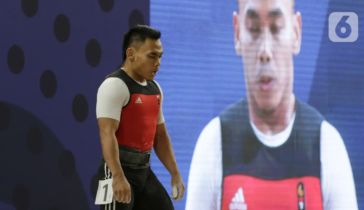 Lifter Eko Yuli bersiap melakukan angkatan saat SEA Games 2019 cabang angkat besi nomor 61 kg di Stadion Rizal Memorial, Manila, Filipina, Minggu (1/12/2019). Dirinya meraih emas dengan total angkatan 309 kg. (Bola.com/M Iqbal Ichsan)