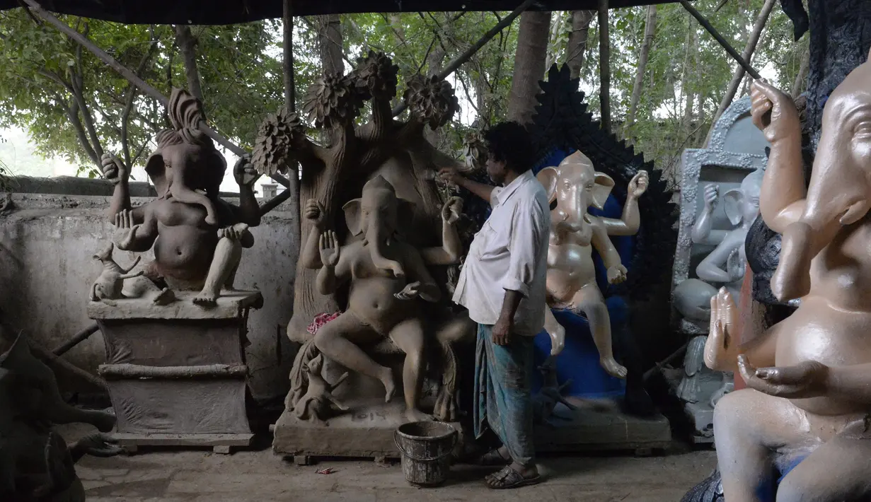 Seorang seniman India menyelesaikan pembuatan patung Dewa Hindu, Lord Ganesh di sebuah lokakarya di Hyderabad (19/8/2019). Festival Ganesh Chaturthi yang diadakan selama sebelas hari akan dirayakan mulai 2 September 2019. (AFP Photo/Noah Seelam)