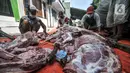 Panitia memotong daging hewan kurban saat perayaan Hari Raya Idul Adha 1442 H di Musala Nurul Huda, Jakarta, Selasa (20/7/2021). Panitia diwajibkan mengenakan masker dan menerapkan protokol kesehatan guna mencegah penyebaran COVID-19. (merdeka.com/Iqbal S. Nugroho)
