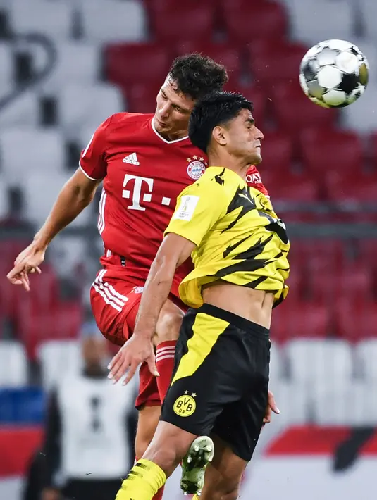 Bek Bayern Munchen, Benjamin Pavard berebut boal dengan pemain Borussia Dortmund Mahmoud Dahoud pada laga Piala Super Jerman di Allianz Arena, Kamis (1/10/2020). Bayern Munich sukses meraih trofi juara Piala Super Jerman 2020 berkat kemenangan 3-2 atas Borussia Dortmund. (Sven Hoppe/Pool via AP)
