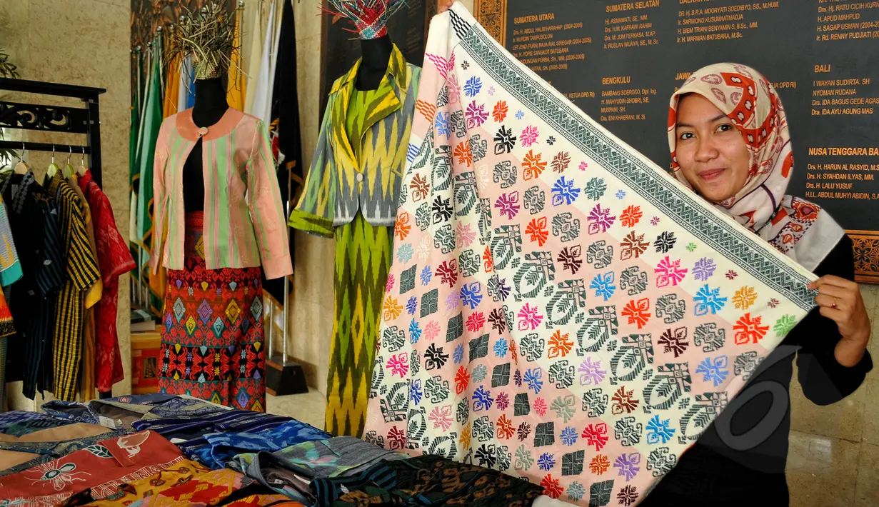 Seorang wanita memperlihatkan kain khas NTB saat pameran di ruang lobi depan DPD-RI komplek parlemen, Senayan, Rabu (15/4/2015). (Liputan6.com/Yoppy Renato)