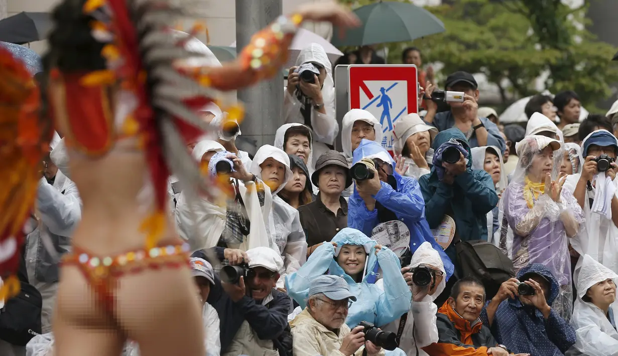 Sejumlah orang mengambil gambar penari samba saat acara tahunan Karnaval Asakusa Samba ke-34 di Tokyo, Jepang, 29 Agustus 2015. Sekitar 5.000 orang berpartisipasi dalam karnaval terbesar yang ada di Jepang ini. (REUTERS/Toru Hanai)