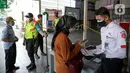 Petugas membantu calon penumpang memindai kode batang (QR Code) melalui aplikasi PeduliLindungi sebelum menaiki KRL di Stasiun Manggarai, Jakarta, Selasa (7/9/2021). PT KAI Commuter melakukan uji coba penggunaan aplikasi PeduliLindungi bagi pengguna KRL di 11 stasiun. (Liputan6.com/Faizal Fanani)