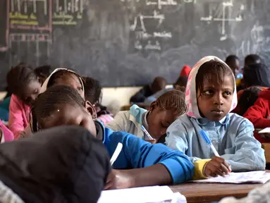 Murid menulis di buku saat menghadiri kelas di sekolah dasar di Pikine, Dakar, (30/1). Pendidikan di Senegal menjadi prioritas saat konferensi ketiga tentang pemulihan dana Kemitraan Global untuk Pendidikan (GPE) mulai 1 Februari 2018. (AFP Photo/Seyllou)