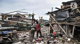 Aktivitas warga dekat tumpukan sampah yang terbawa arus laut di permukiman nelayan Cilincing, Jakarta Utara, Rabu (8/6/2022). Jumlah sampah di laut Nusantara secara keseluruhan diperkirakan sudah mencapai 5,75 juta ton. (merdeka.com/Iqbal S. Nugroho)