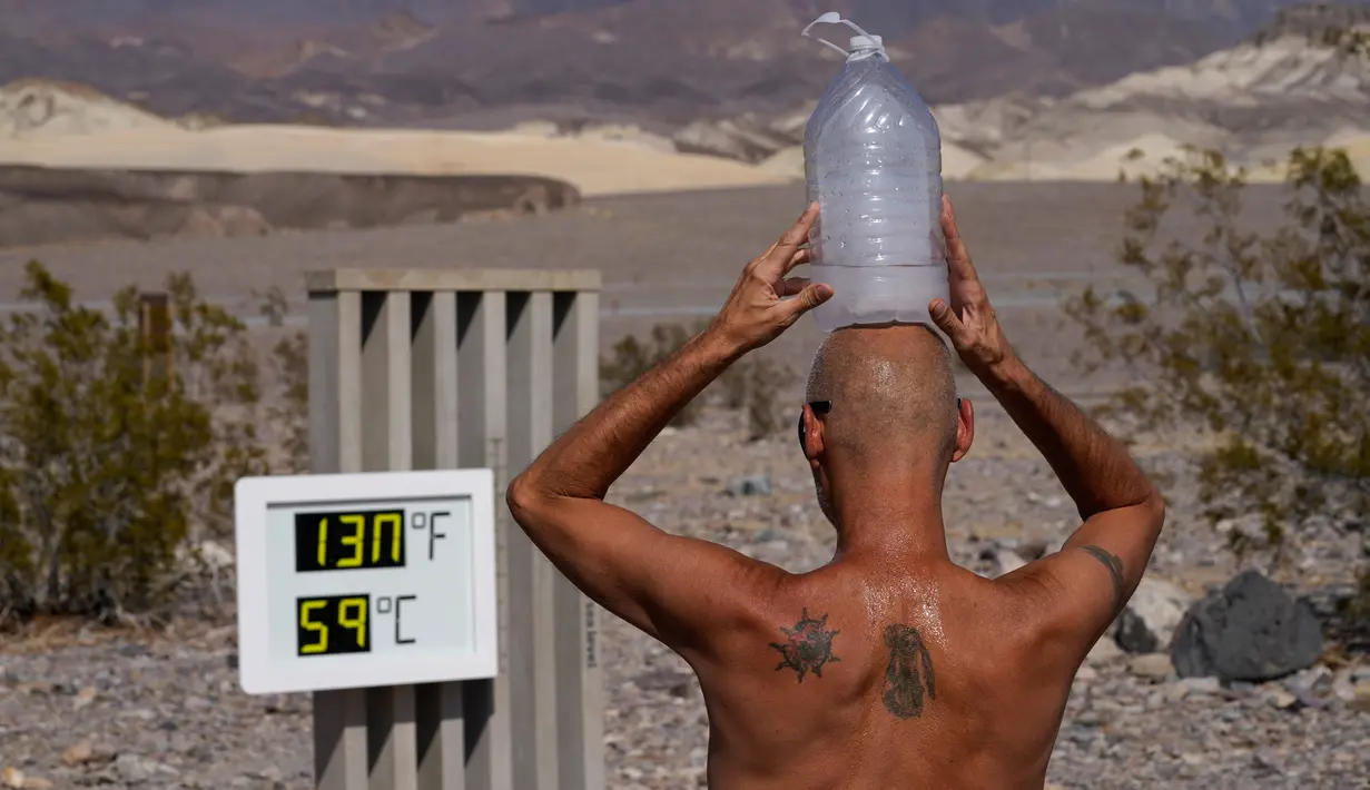 Steve Krofchik mendinginkan kepalanya dengan botol berisi es batu di Taman Nasional Death Valley, California, Amerika Serikat, Senin (17/8/2020). Temperatur udara tertinggi di Dunia -- 54,4 derajat Celcius -- tercatat di Taman Nasional Death Valley pada Minggu 16 Agustus. (AP Photo/John Locher)