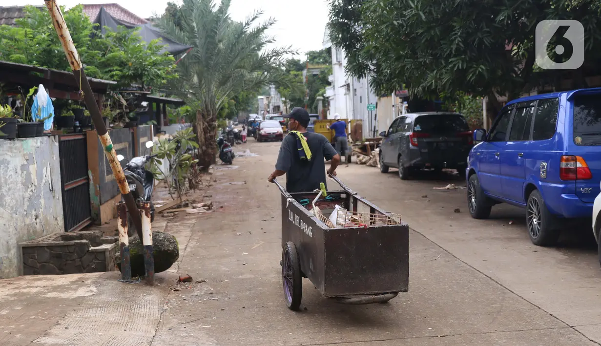 Pengumpul barang bekas berkeliling di Ciledug Indah, Tangerang, Banten, Senin (21/2./2021). Pasca banjir melanda perumahan tersebut menjadi berkah bagi para pengumpul barang rongsok karena banyak barang yang di buang pemilik rumah. (Liputan6.com/Angga Yuniar)