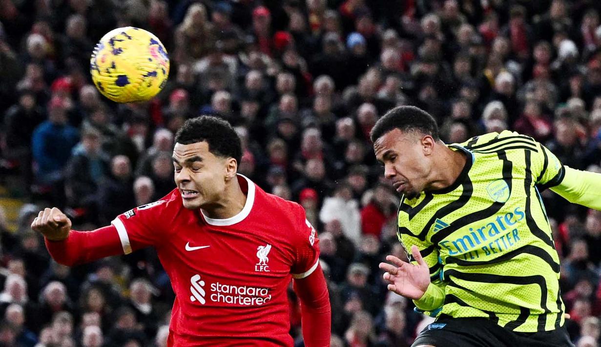 Pemain Arsenal, Gabriel Magalhaes, mencetak gol melalui tandukan kepala ke gawang Liverpool pada laga pekan ke-18 Premier League 2023/2024 di Stadion Anfield, Minggu (24/12/2023). Arsenal unggul lebih dulu pada menit ke-4 lewat gol Gabriel Magalhaes. Liverpool lantas membalas melalui gol Mohamed Salah pada menit ke-29. (AFP/Paul Ellis)